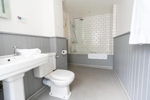 a bathroom with a white toilet and a sink at Tyacks Hotel in Camborne