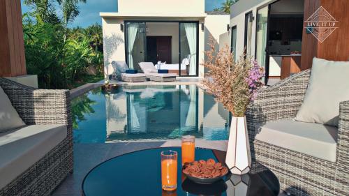 a patio with a table with a vase on it at Santi Tara Villas in Amphoe Koh Samui