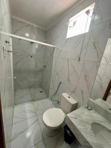 a bathroom with a shower and a toilet and a sink at Hotel Padre Cícero in Lavras da Mangabeira