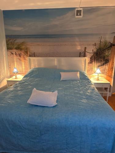 a blue bed with two pillows on top of it at Dahlias Bed & Breakfast in Väderstad
