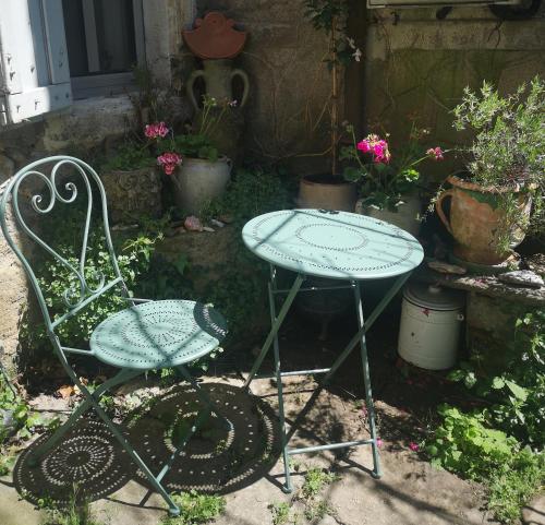 two chairs and a table in a garden with flowers at Une chambre au jardin in Saint-Pons-de-Thomières