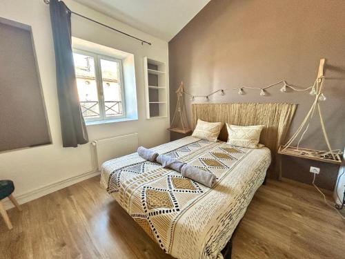 - une chambre avec un grand lit dans une pièce dotée d'une fenêtre dans l'établissement Le Nid Tropical Proche gare, à Villefranche-sur-Saône