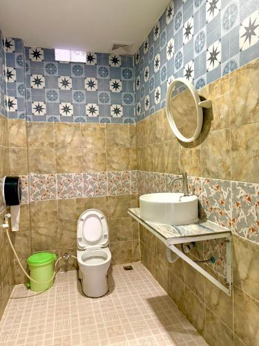 Un baño con inodoro, lavabo y espejo. en Vang Vieng Dragon House, en Vang Vieng