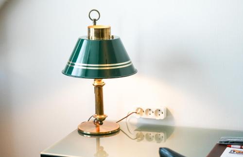 a green lamp sitting on top of a desk at Hotel Kryb I Ly Kro in Taulov