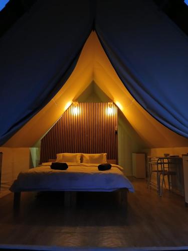 a bedroom with a bed in a tent at Veselia Glamping in Valea Drăganului
