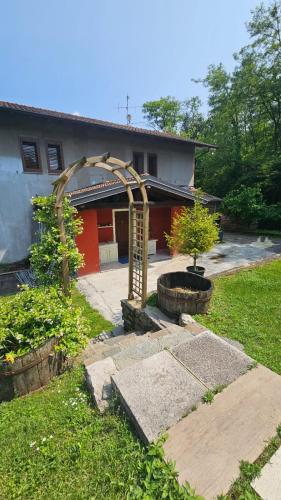 a house with an arch in front of a yard at Agriturismo dei Laghetti in Porto Valtravaglia