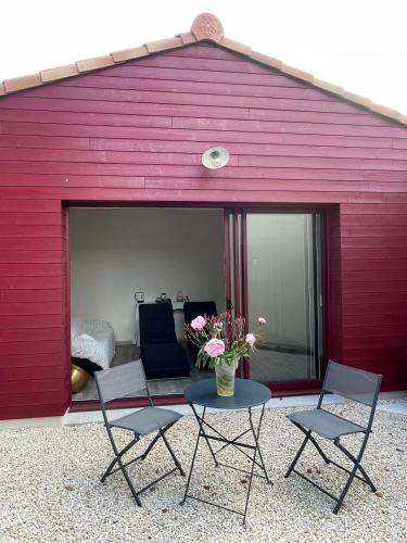 a red building with a table and chairs and a couch at Villa Rosso in Clisson