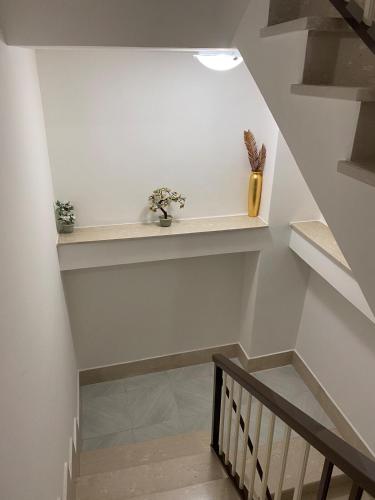 a staircase with white walls and a stair case with flowers at Intera casa in centro storico a 800mt dal mare in Policastro Bussentino