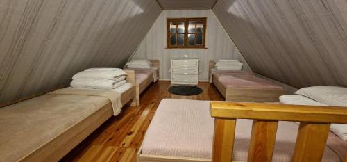 Zimmer im Dachgeschoss mit 4 Betten und einem Fenster in der Unterkunft Leśna Ostoja in Radowo Małe