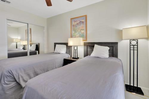 a hotel room with two beds and a mirror at Indian Palms Villas in Indio