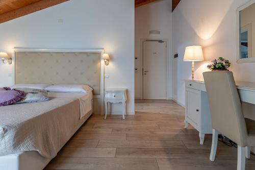 a bedroom with a bed and a table and a desk at Agriturismo Casa Rossa in Postioma