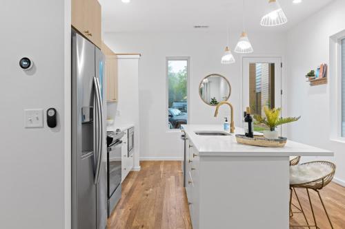a kitchen with a sink and a refrigerator at Azul - An Atomic Ridge Home in Chattanooga