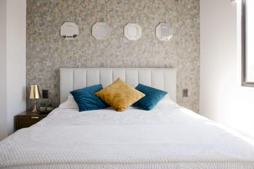 a bedroom with a white bed with blue pillows at Villa city, Ciudad Guatemala, EON zona 10 in Estación Pamplona