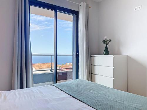 a bedroom with a bed and a large window at Atlantic Haven by Atlantic Holiday in Garajau