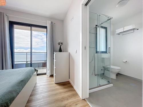 a bedroom with a glass shower and a toilet at Atlantic Haven by Atlantic Holiday in Garajau