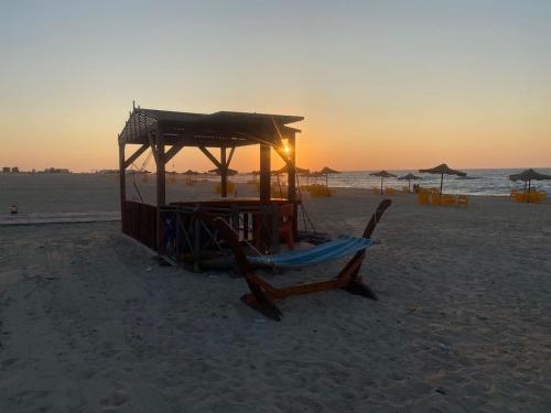 a lifeguard stand on a beach at sunset at Your Perfect Getaway, Luxury Chalet in Lamera, Ras El Hekma in Zāwiyat al ‘Awwāmah