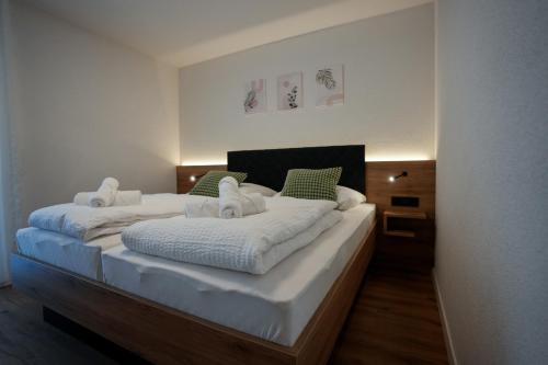 a bedroom with two beds with white sheets and green pillows at Be Grand Apartments Rust in Rust