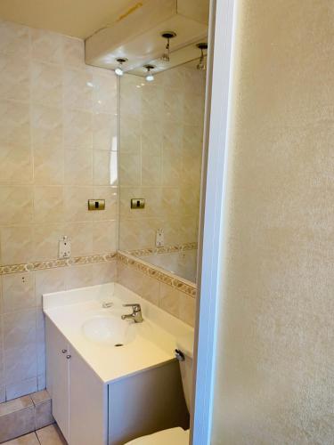 a bathroom with a sink and a mirror at BbCasita Blue in Santiago
