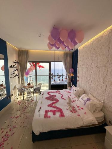 a bedroom with a large bed with pink balloons at برج داماك الكورنيش الجناح اليوناني Damac jeddah Tower in Jeddah