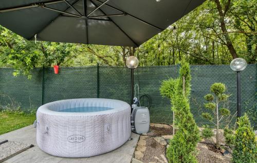 eine Badewanne unter einem Sonnenschirm in einem Hof in der Unterkunft Nice Home In Castiglion Fiorentino in Castiglion Fiorentino