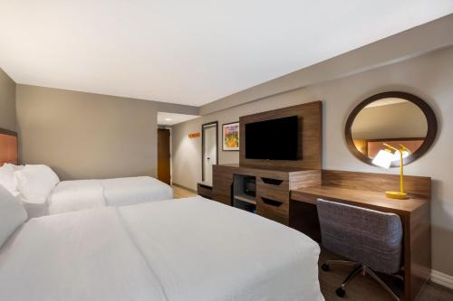 a hotel room with a bed and a desk with a television at Hampton Inn Philadelphia/Willow Grove in Willow Grove