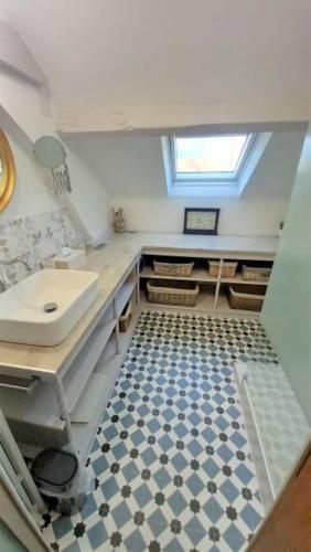 La salle de bains est pourvue d'un lavabo et de carrelage. dans l'établissement La Maison de Sylvie, chambres d'hôtes à Tarbes, à Tarbes