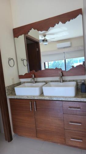 a bathroom with two sinks and a large mirror at Casa con alberca privada in Puerto Vallarta