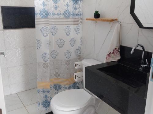 a bathroom with a white toilet and a sink at Vila Negreiros Serra Negra Casa 4 in Bezerros