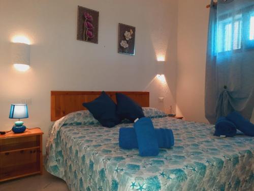 a bedroom with a bed with blue sheets and blue pillows at Villette Vista Mare in Rena Majore