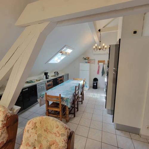 une cuisine avec une table et des chaises dans une pièce dans l'établissement Au bord du Foron, à Scionzier