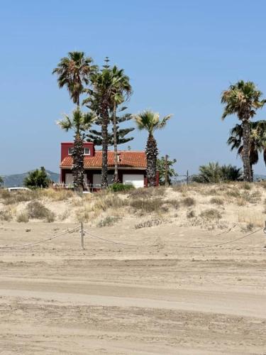 a house on the beach with palm trees at Villa Grao Benicasim REF 026 in Grao de Castellón