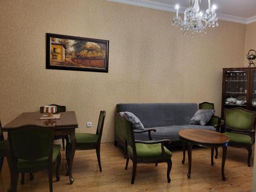 a living room with a couch and a table and chairs at Cozy Retro Apartment Near the Sea in P'ichvnari