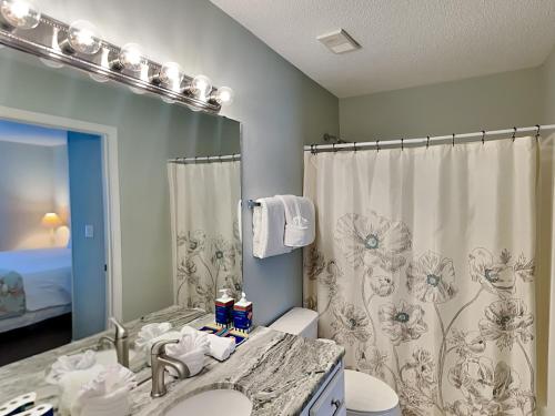 a bathroom with a sink and a toilet and a mirror at Grand Caribbean Perdido Key #306 West in Perdido Key