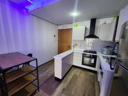 a kitchen with white cabinets and a table in it at Fontaine in Nabeul