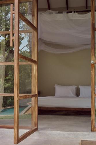 a bed in a room with a window at The Kip in Ahangama