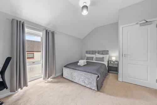 a white bedroom with a bed and a window at Modern Bannockburn Guest House - Ensuite Rooms Only in Bannockburn