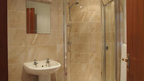 a bathroom with a sink and a shower at Pantile Lodge in Milfield
