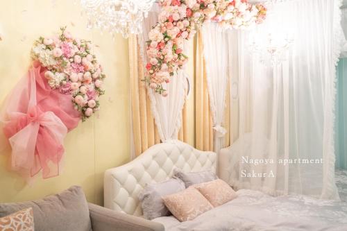 a bedroom with a bed and flowers on the wall at SakurA in Nagoya