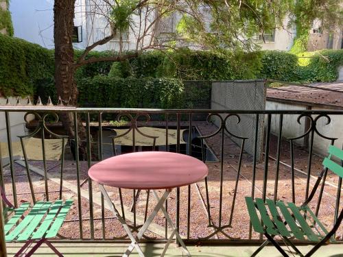 a pink chair and two green chairs on a balcony at BbCasita Blue in Santiago