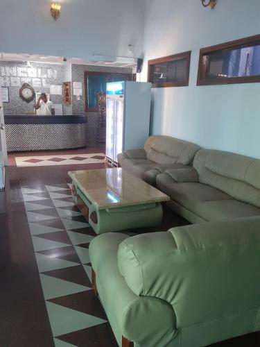 a living room with a couch and a coffee table at Lincoln Prestige Hotel in Accra