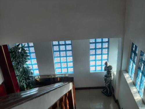 a person standing in a room with windows at Lincoln Prestige Hotel in Accra