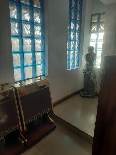 a statue of a woman in a room with windows at Lincoln Prestige Hotel in Accra