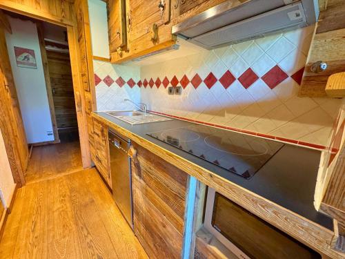 une cuisine avec un évier et une cuisinière dans l'établissement Studio avec lit clos savoyard et coin montagne au pied des pistes - FR-1-452-101, aux Menuires