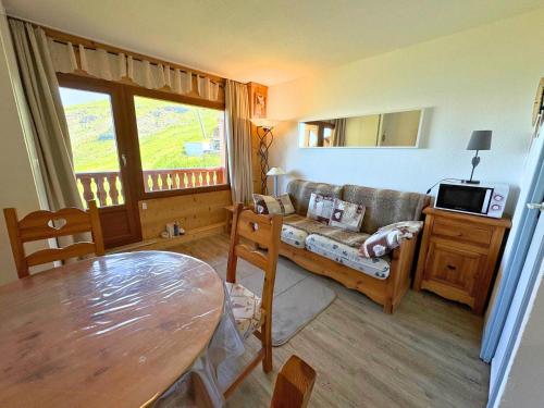 un salon avec un canapé et une table dans l'établissement Studio cabine cosy aux Menuires, 3 pers, pied des pistes, balcon, proche commodités - FR-1-452-291, aux Menuires