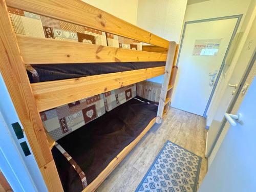 Ce lit superposé se trouve dans un dortoir doté d'un couloir. dans l'établissement Studio cabine cosy aux Menuires, 3 pers, pied des pistes, balcon, proche commodités - FR-1-452-291, aux Menuires