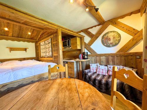 une chambre avec un lit et une table dans une pièce dans l'établissement Studio Style Chalet pour 3 Pers, Balcon, Pied des Pistes, Réberty 2000 - FR-1-452-85, aux Menuires