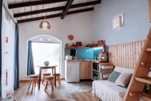 a living room with a table and a kitchen at Castle House and Beach in Sines