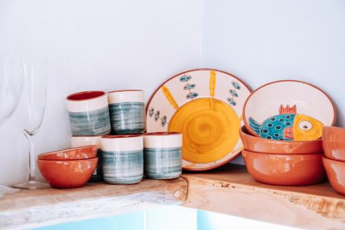 a shelf with bowls and plates on it at Castle House and Beach in Sines