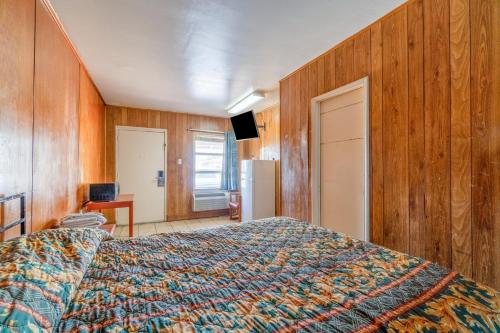 a bedroom with a bed and wooden walls at Gulfway Motel By OYO Near Airport I 37 in Corpus Christi