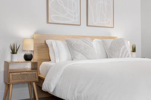 a bedroom with a white bed with a wooden headboard at Mango House en Dania Beach in Dania Beach